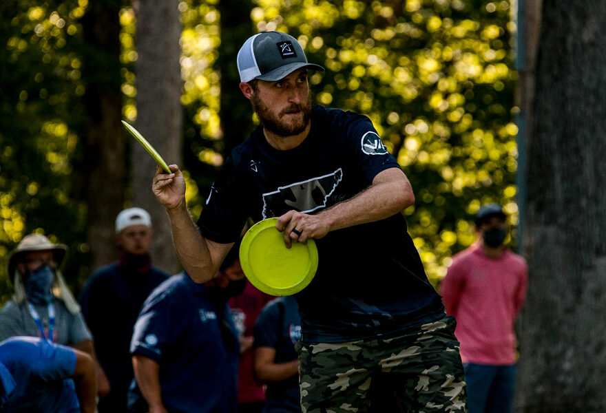 A professional disc golfer throwing a forehand anhyzer shot